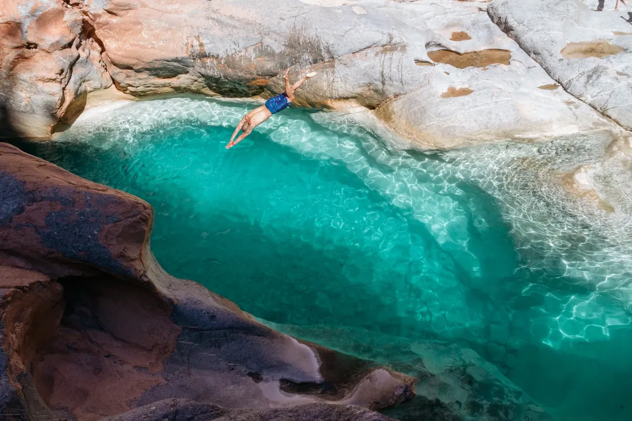 Swimmer diving into turquoise natural pools in Paradise Valley near Agadir