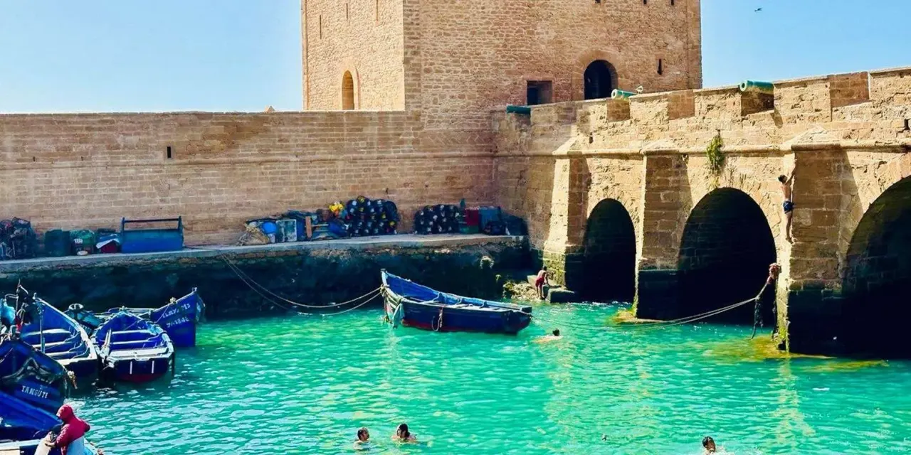Blue fishing boats in the harbour below the ramparts of Essaouira, Morocco