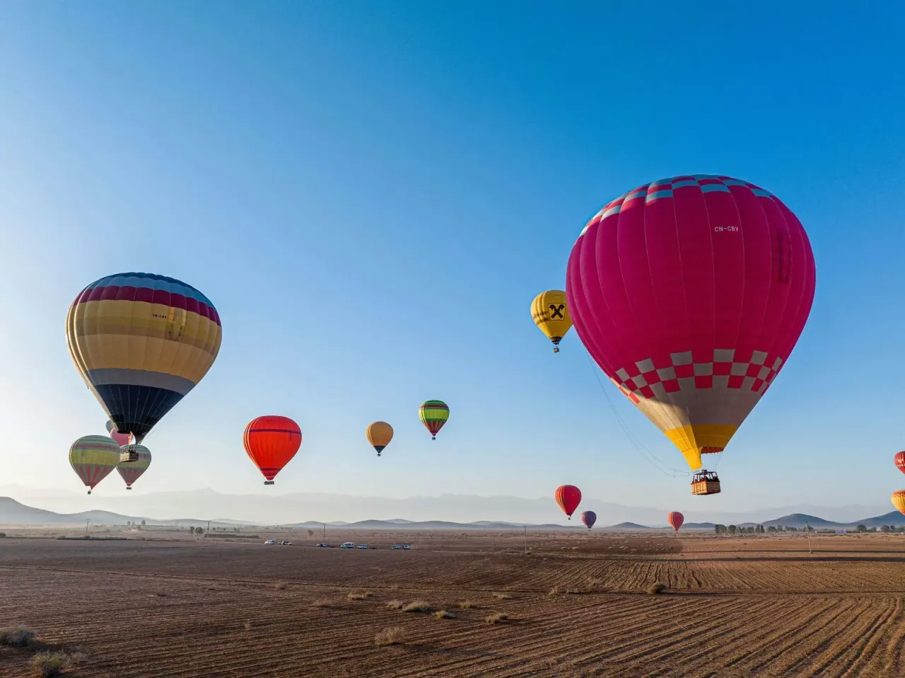 Hot air balloons drifting over the Souss plain at sunrise near Agadir, Morocco