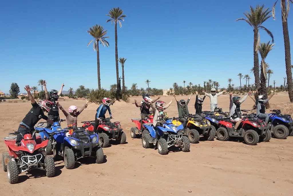 Group of quad bikers lined up under palm trees at the Marrakech Palmeraie