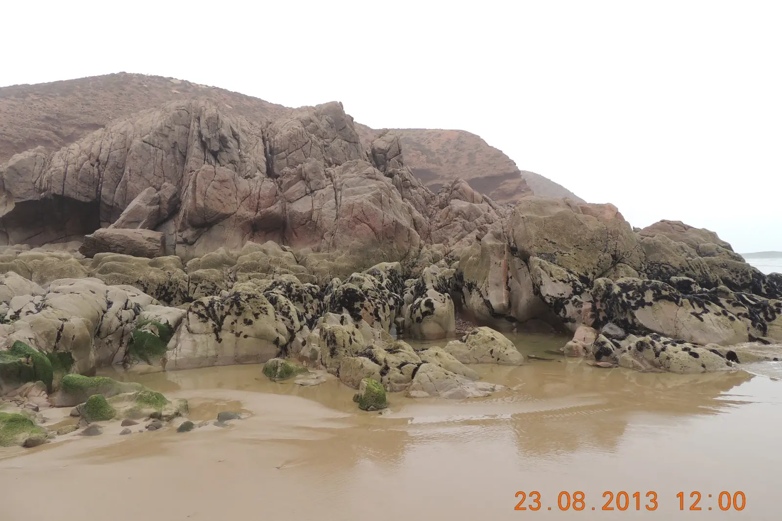Red sandstone arch at Legzira beach with the Atlantic breaking behind it