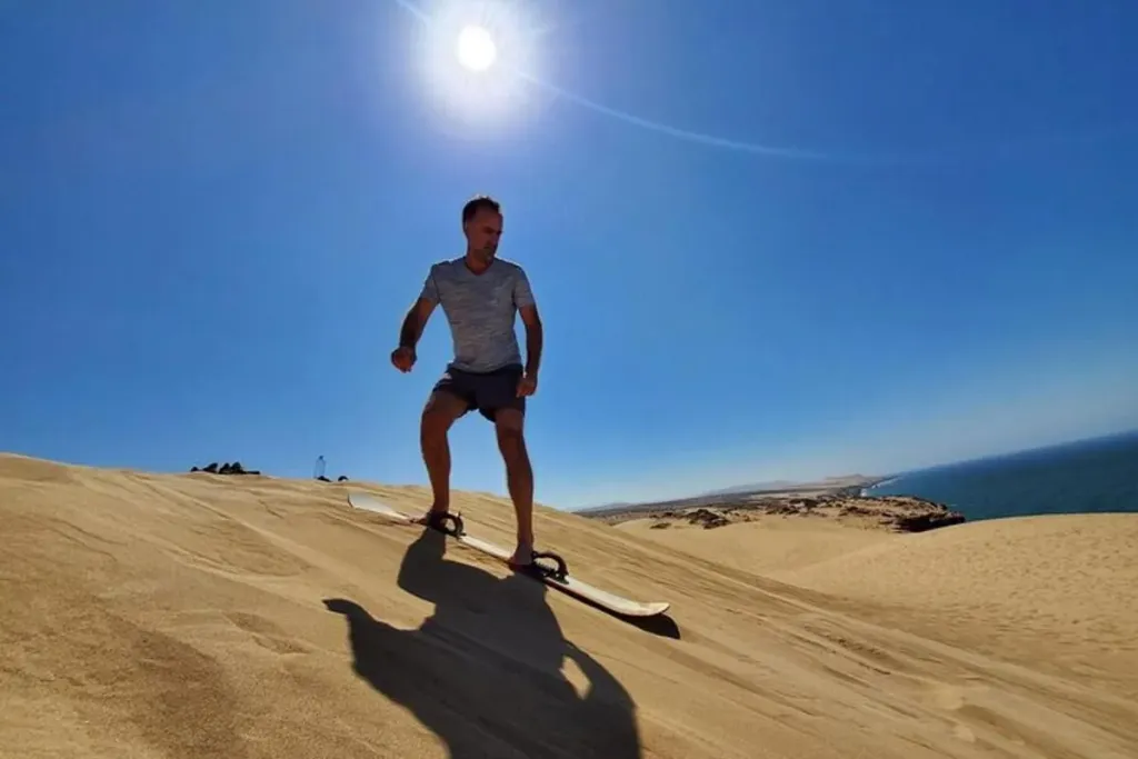 Sandboarder on the Timlalin dunes where the desert meets the Atlantic near Agadir