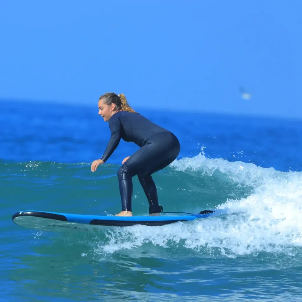 Surfer riding a wave during a beginner surf lesson near Agadir, Morocco